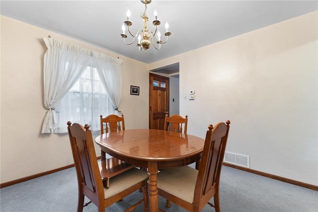 dining area with carpet and a notable chandelier