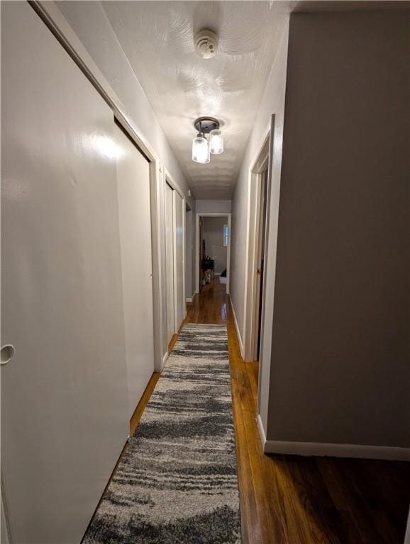 corridor with dark hardwood / wood-style floors