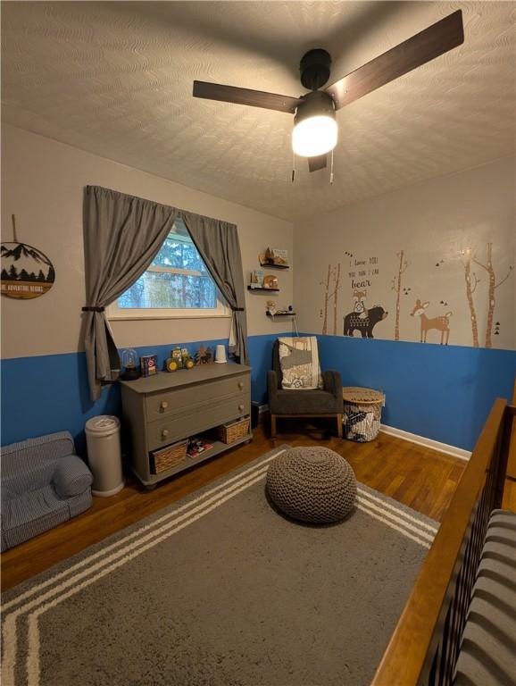 sitting room featuring a textured ceiling, hardwood / wood-style flooring, and ceiling fan