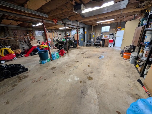 garage featuring electric water heater, white fridge, and a garage door opener