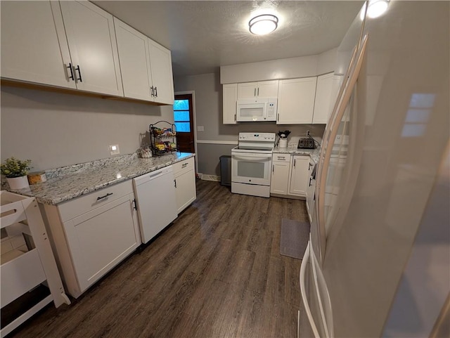 kitchen with light stone countertops, white appliances, white cabinetry, and dark wood-type flooring