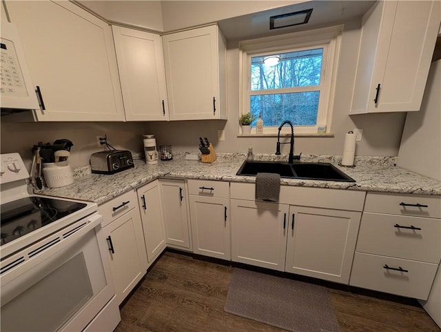 kitchen with white appliances, white cabinetry, dark wood-type flooring, and sink