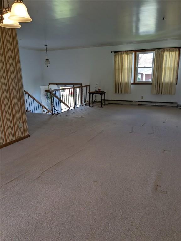 carpeted empty room with a baseboard radiator