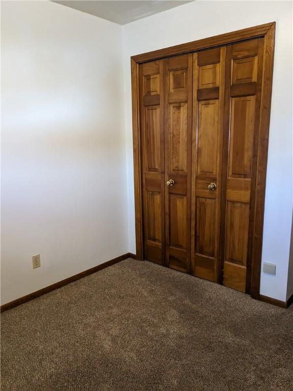 unfurnished bedroom featuring dark colored carpet