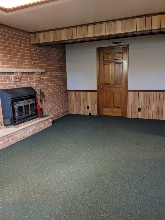 unfurnished living room featuring carpet flooring and a wood stove