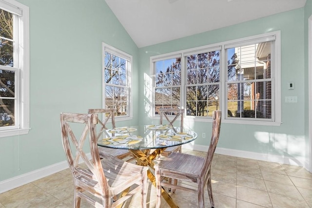 tiled dining space featuring plenty of natural light and vaulted ceiling