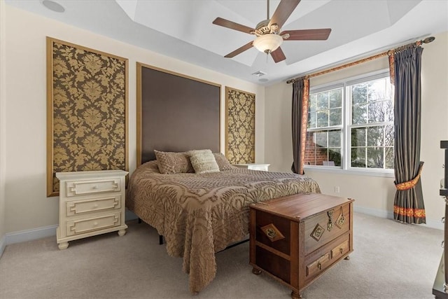 bedroom with carpet flooring, ceiling fan, and a tray ceiling