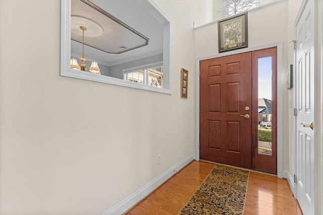 foyer entrance featuring light hardwood / wood-style floors and a chandelier