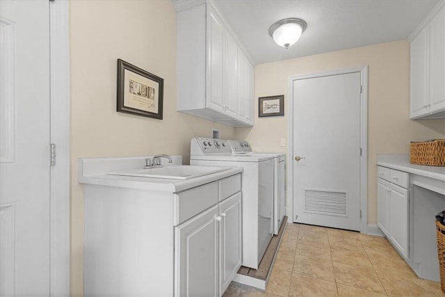 laundry room with washing machine and dryer, sink, light tile patterned floors, and cabinets