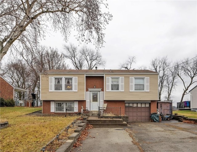 split foyer home featuring a garage and a front lawn