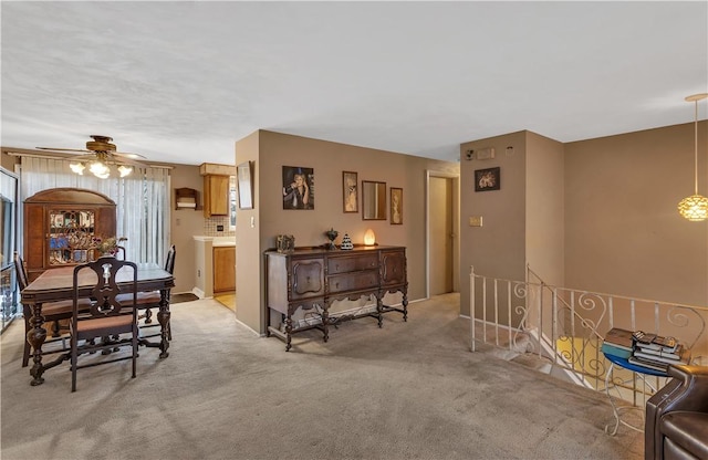 dining area with light colored carpet and ceiling fan