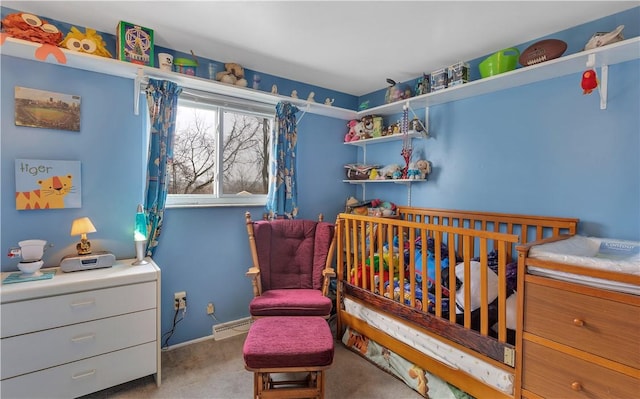 bedroom with light colored carpet, a crib, and a baseboard heating unit