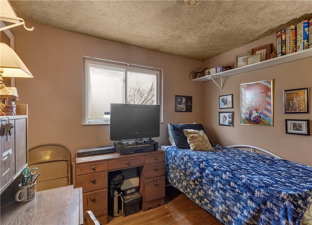 bedroom featuring wood-type flooring and a textured ceiling