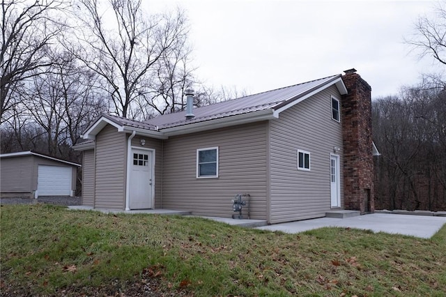 back of house with a lawn and an outbuilding