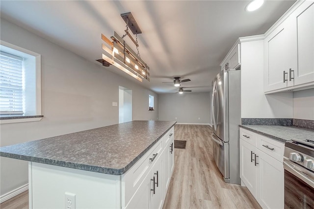 kitchen with a center island, white cabinets, light hardwood / wood-style flooring, ceiling fan, and stainless steel appliances