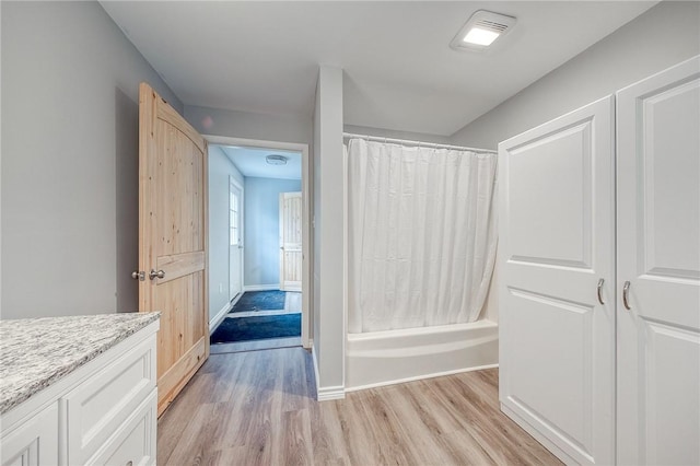 bathroom with vanity, hardwood / wood-style flooring, and shower / bathtub combination with curtain