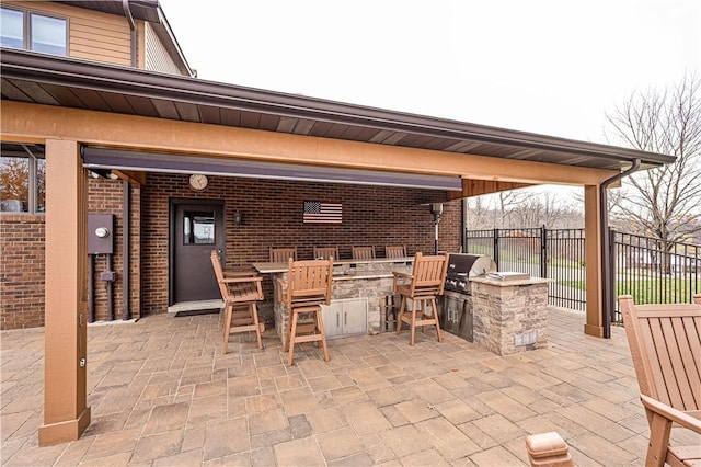 view of patio featuring a bar, an outdoor kitchen, and grilling area