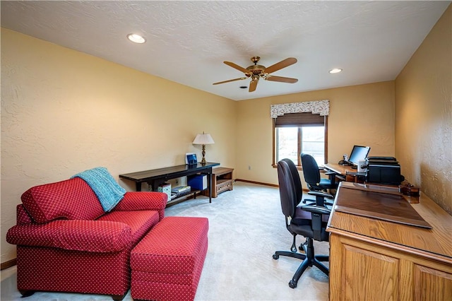 carpeted home office with ceiling fan and a textured ceiling