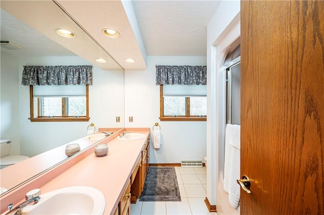 bathroom with toilet, plenty of natural light, vanity, and tile patterned flooring