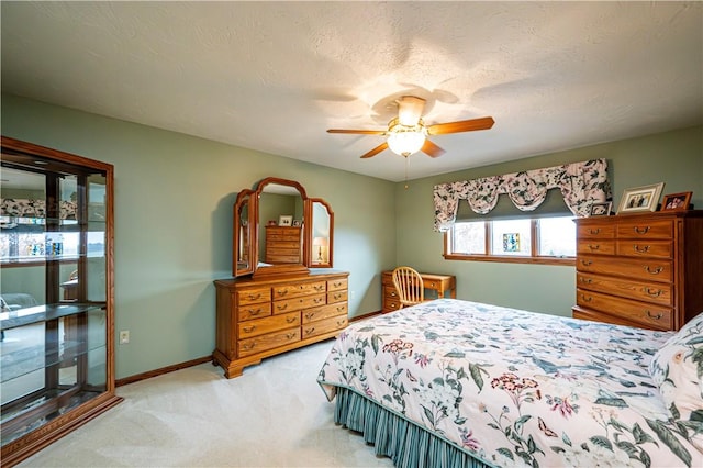 carpeted bedroom featuring ceiling fan and a textured ceiling