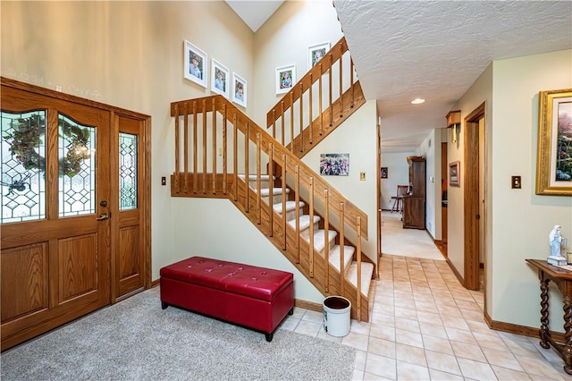 entrance foyer with light tile patterned flooring and a textured ceiling