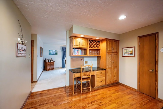 office featuring light hardwood / wood-style flooring and built in desk