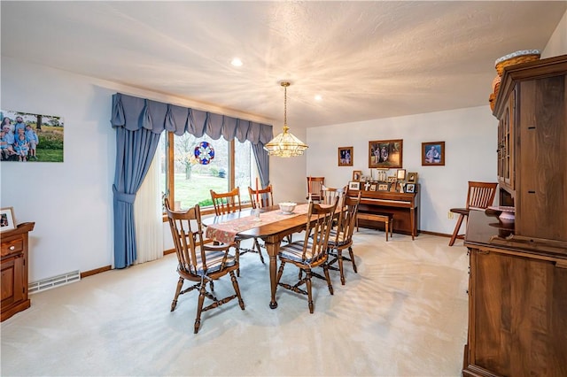 carpeted dining area featuring an inviting chandelier