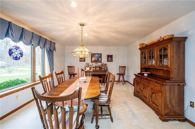 dining area featuring light colored carpet and a chandelier