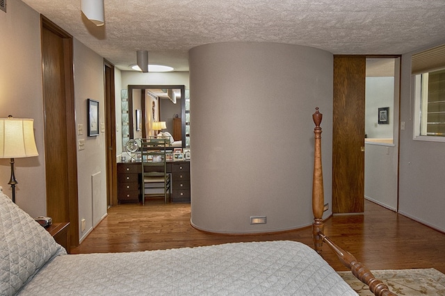 bedroom with ceiling fan, a textured ceiling, and hardwood / wood-style flooring