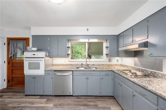 kitchen with gray cabinets, sink, appliances with stainless steel finishes, and light hardwood / wood-style flooring