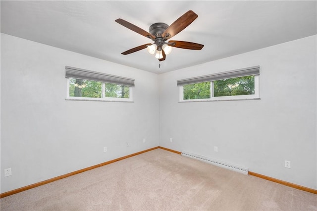 carpeted spare room with ceiling fan and a baseboard heating unit