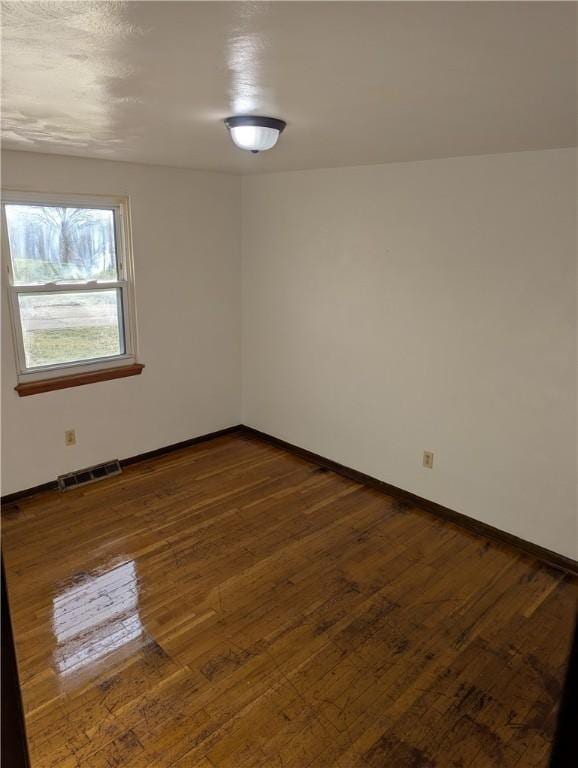 spare room with dark hardwood / wood-style flooring