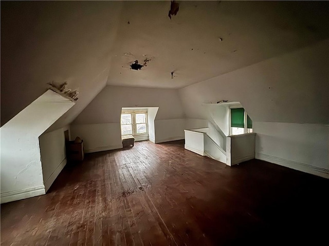 bonus room with dark hardwood / wood-style flooring and lofted ceiling