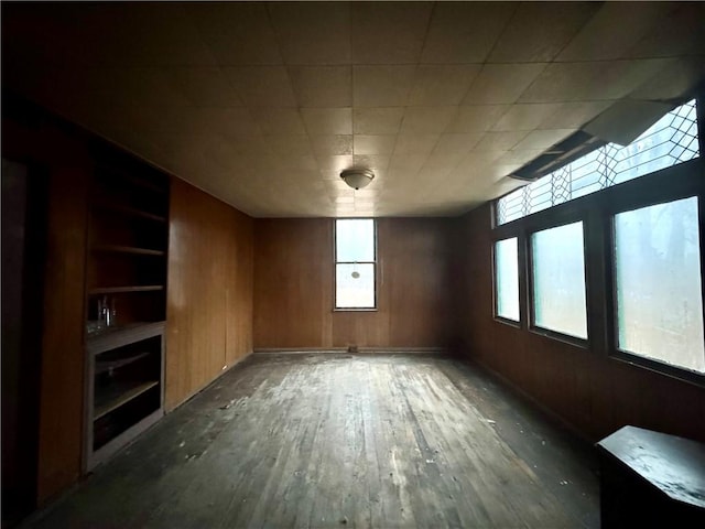 spare room featuring wood walls and dark hardwood / wood-style floors