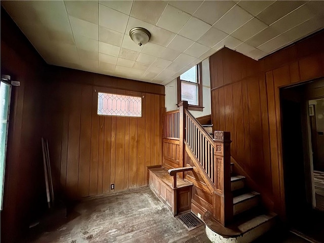 stairs featuring wood walls