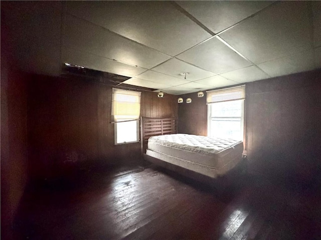 unfurnished bedroom featuring a paneled ceiling and dark wood-type flooring