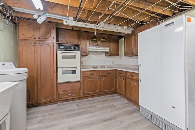 kitchen with white appliances and light hardwood / wood-style flooring