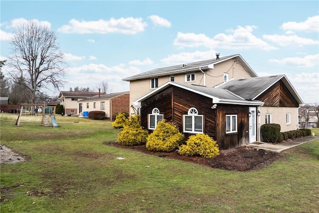 view of side of home with a playground and a yard