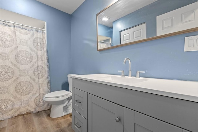 bathroom with hardwood / wood-style floors, vanity, and toilet