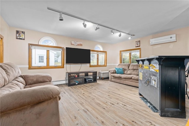 living room with a wall unit AC, track lighting, light hardwood / wood-style floors, and a baseboard radiator