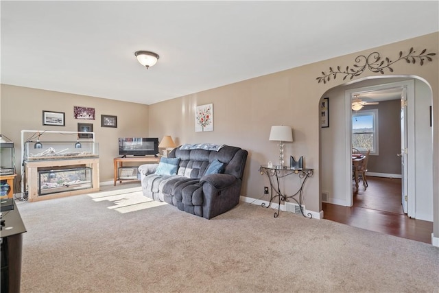 carpeted living room with ceiling fan