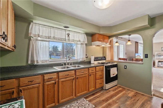 kitchen featuring light wood-type flooring, white range with gas stovetop, and sink