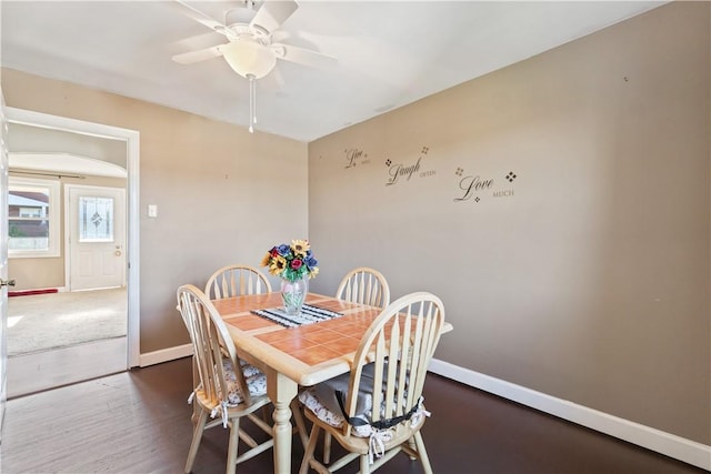 dining area featuring dark hardwood / wood-style flooring and ceiling fan