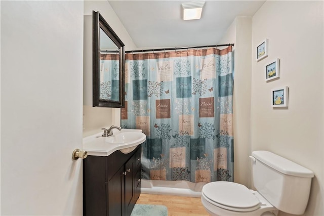 full bathroom with shower / bathtub combination with curtain, hardwood / wood-style flooring, vanity, and toilet