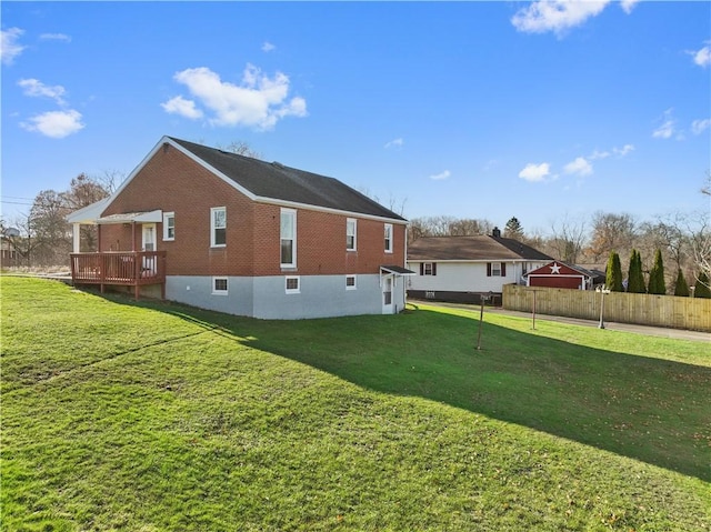 view of side of property with a deck and a yard