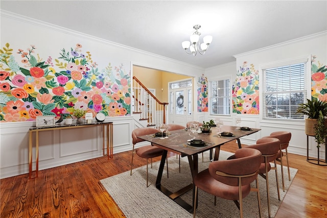 dining room featuring hardwood / wood-style floors, an inviting chandelier, and crown molding