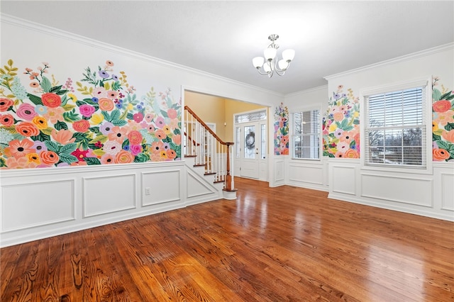 foyer featuring hardwood / wood-style flooring, a notable chandelier, and ornamental molding