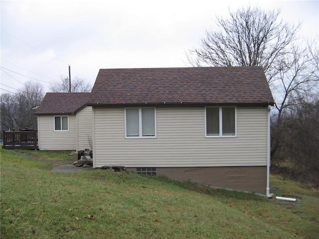 view of side of home featuring a lawn and a deck