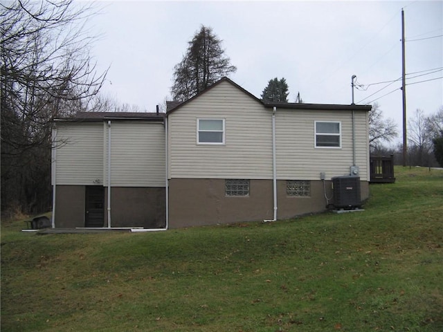 view of side of property featuring a lawn and central air condition unit