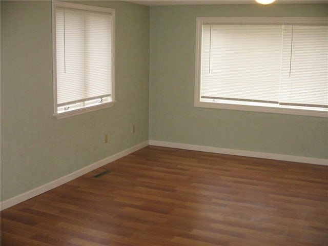 spare room with dark wood-type flooring